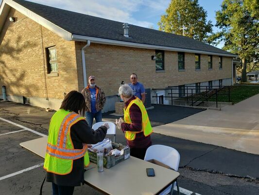 Pictured are Fr. John Henderson and Cassie Gonzalez with St. Williams parish at the table and in the back are Rick Ellison and Lamar Utterback.