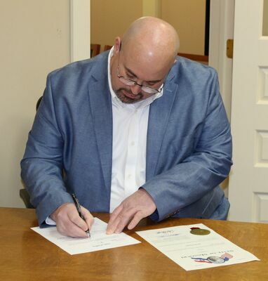 Brad Stinson wraps up the paperwork after being sworn in as the new Ralls County Sheriff.